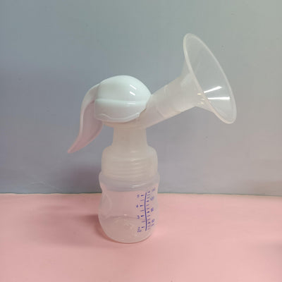 Manual breast pump on a pink surface with a light gray background