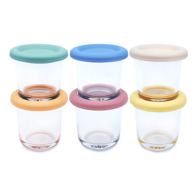 Three glass jars with colorful lids on a white background