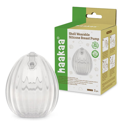 Clear shell-shaped silicone breast pump with packaging on a white background