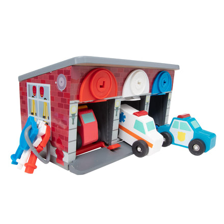 Toy fire station with colorful cars and figures on a white background